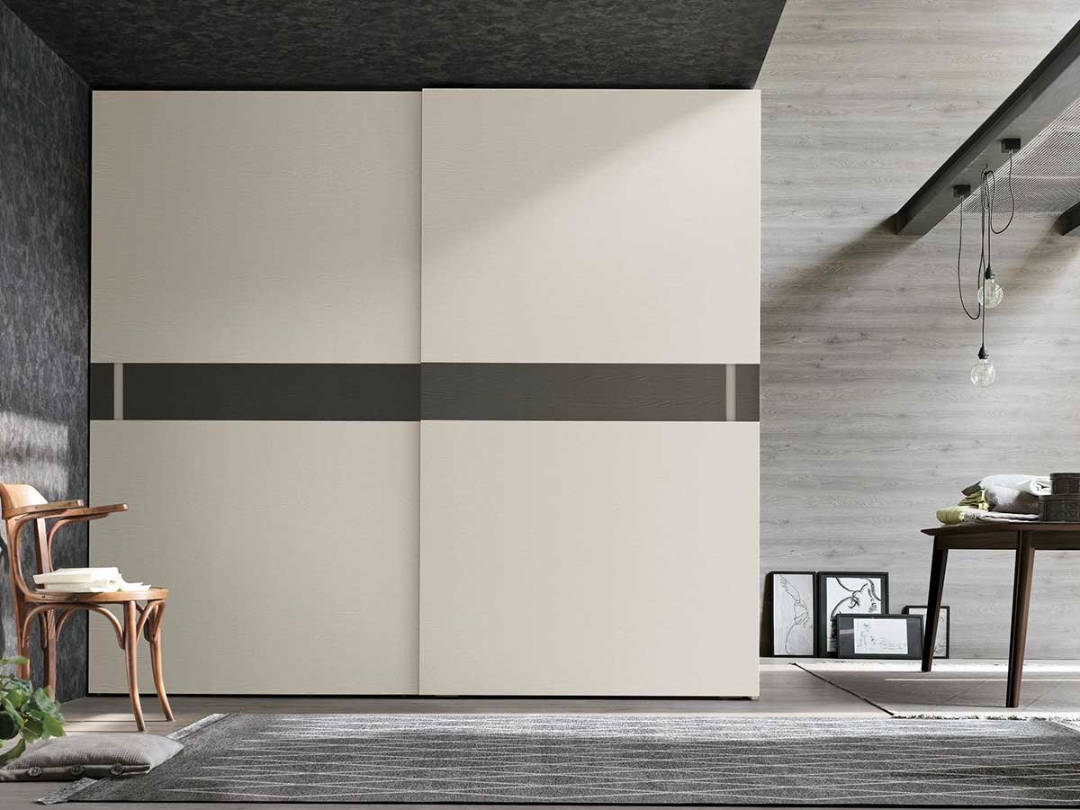 Große beige Schrankwand mit Holzstuhl vor grauen Wänden