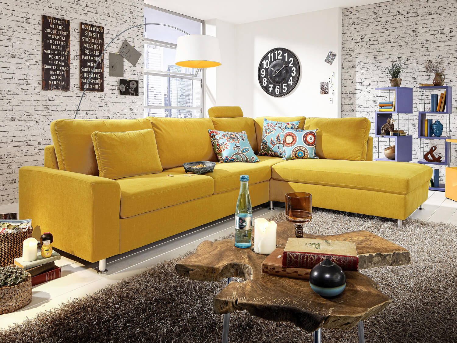 Gelbes Sofa mit Stoffbezug und vielen Kissen